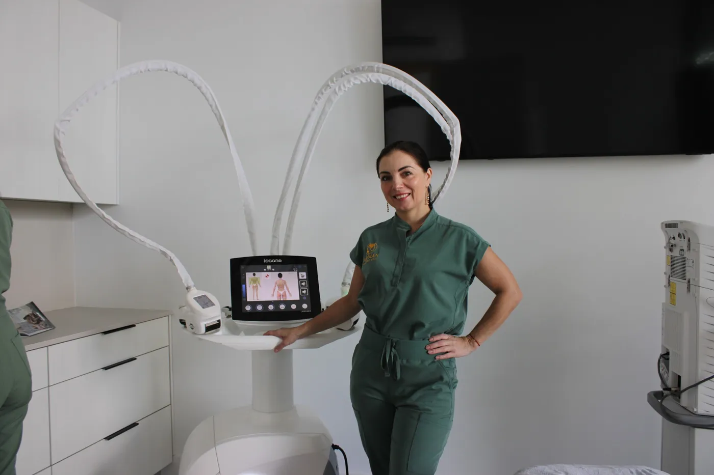 A WO/MAN specialist beside a body treatment device in a bright treatment room