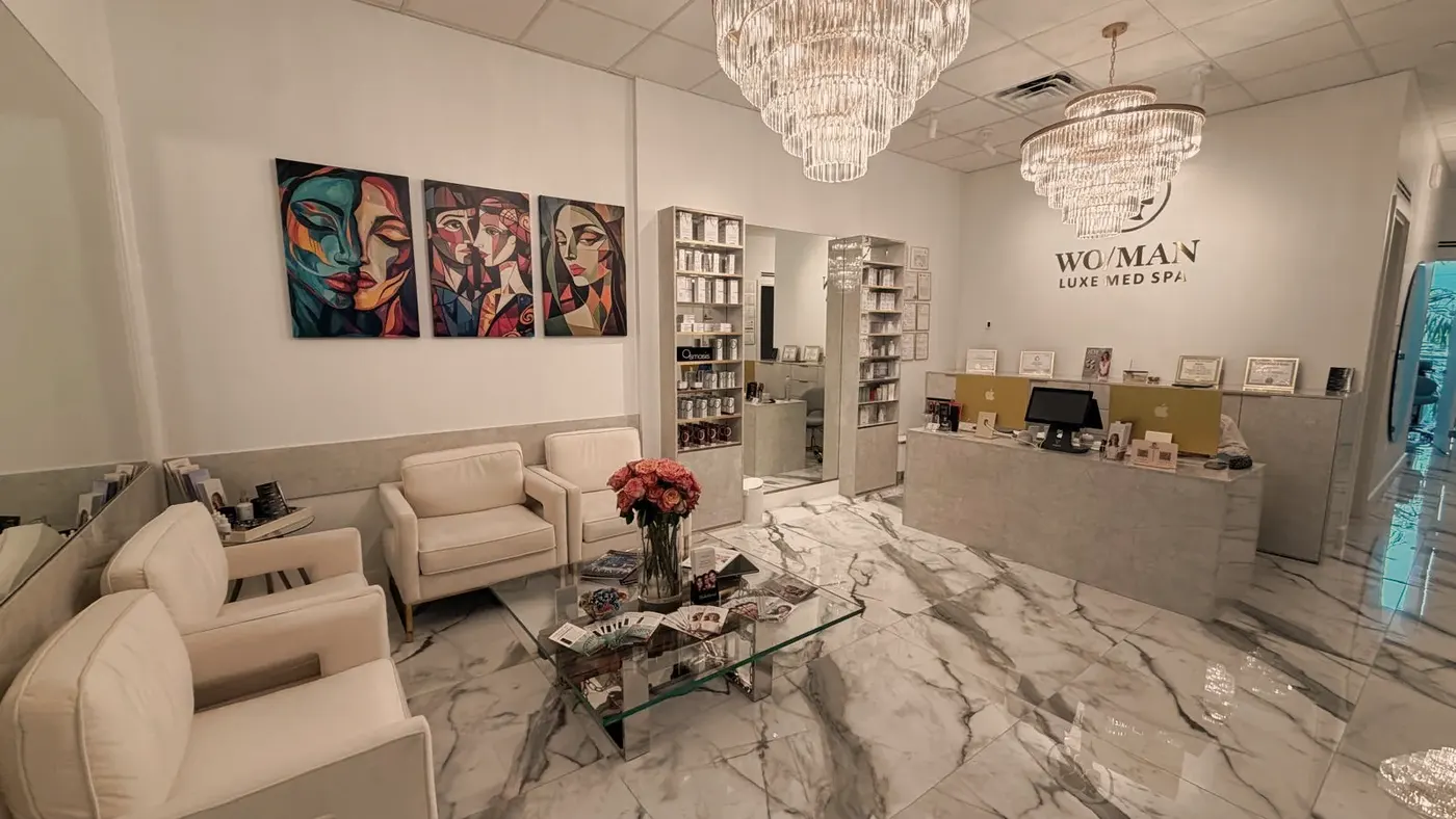 The WO/MAN lounge with cream armchairs, coral roses and crystal chandeliers